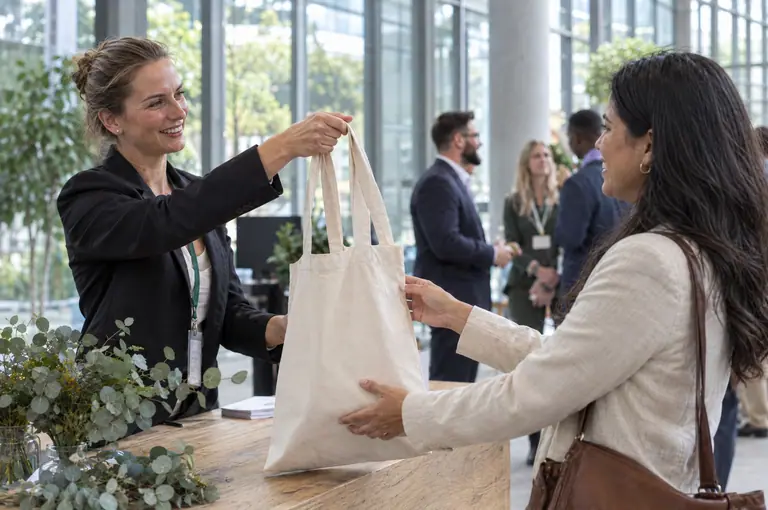 EU-made cotton bag being handed out as a giveaway at a corporate event